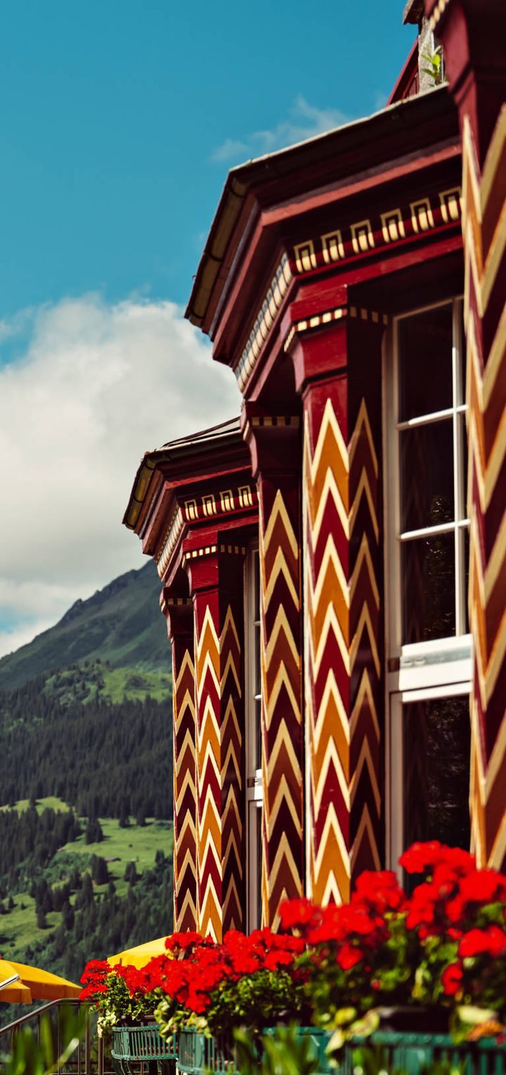 The Belvedere's painted zigzag columns and red geraniums, close up