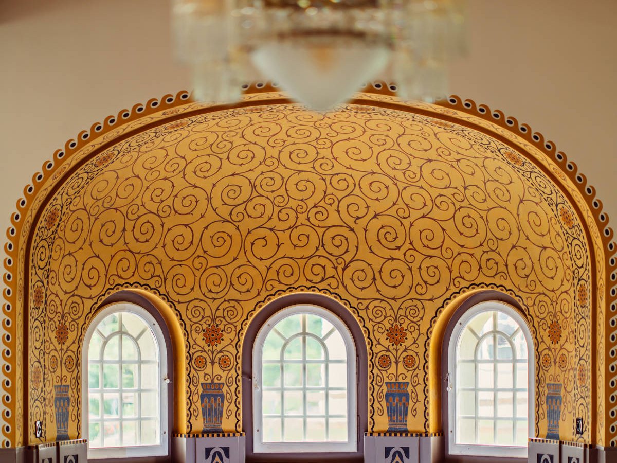 The Brasserie Belvedere under painted Art Nouveau arches and a golden patterned ceiling