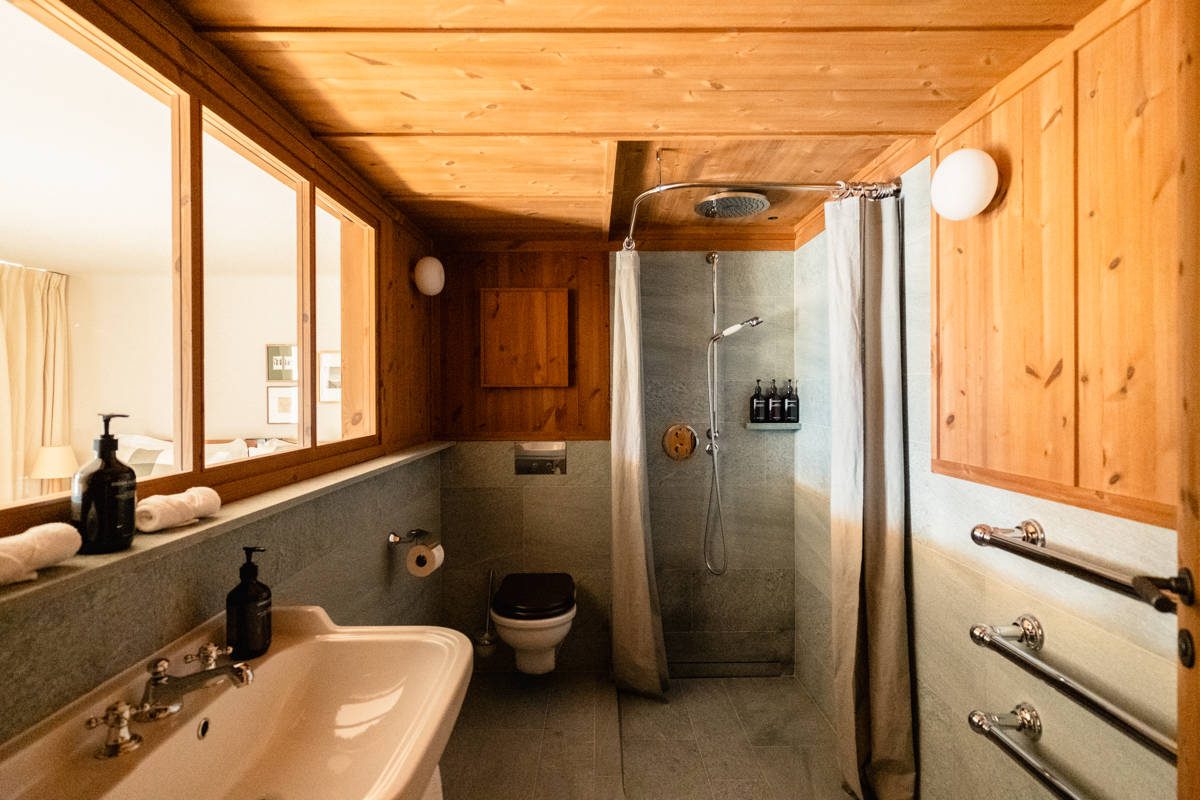 A Deluxe room in spruce panelling with a red armchair