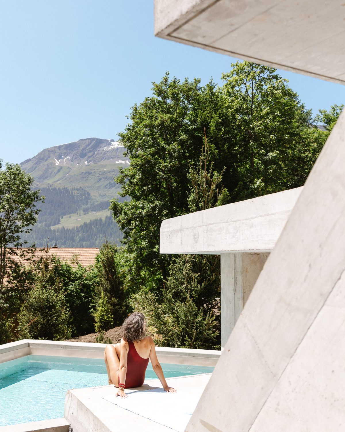 A guest in the outdoor pool, snowy peaks above